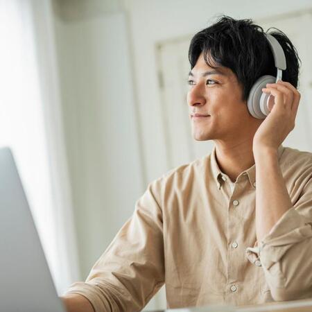 リモートワークで音楽を聴く男性　※画像はイメージです（One/stock.adobe.com）