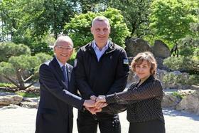 　４月３０日、キーウの「京都公園」での式典で握手するクリチコ市長（中央）と松田邦紀駐ウクライナ大使（左）ら（共同）