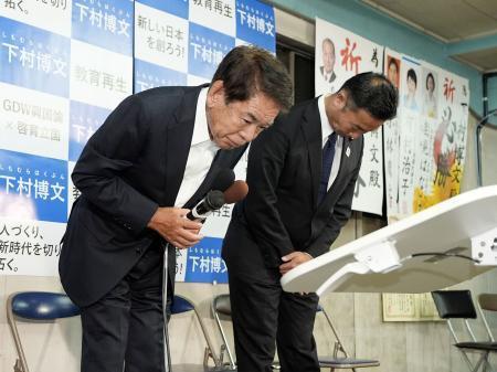 　東京１１区で落選が決まり、支持者らに頭を下げる下村博文氏（左）＝２７日夜、東京都板橋区