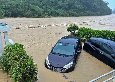 　沖縄県国頭村の比地川があふれ、水に漬かった乗用車＝１０日午前（国頭村提供）