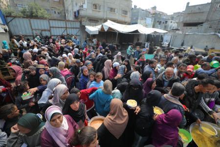 　支援組織による食事の配給に集まるパレスチナの人々＝１５日、ガザ地区デールバラハ（アナトリア通信提供、ゲッティ＝共同）
