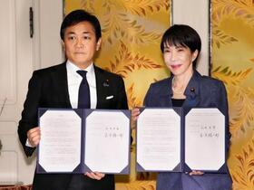 　国会内で会談し「年収の壁」引き上げを巡る合意書を手にする高市首相（右）と国民民主党の玉木代表＝１８日午後