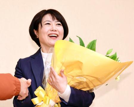 　前橋市長選で再選を決め、花束を手にする小川晶氏＝１２日夜、前橋市