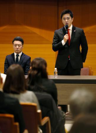 　所属地方議員らを集めた緊急会議であいさつする日本維新の会代表の吉村洋文大阪府知事。左は副代表の横山英幸大阪市長＝１５日午後、大阪市中央区