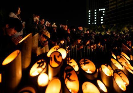 　阪神大震災から３１年となり、発生時刻に合わせて黙とうする人たち＝１７日午前５時４６分、神戸市中央区の東遊園地