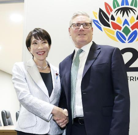 　スターマー英首相（右）と握手する高市首相＝２０２５年１１月、南アフリカのヨハネスブルク（共同）