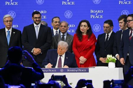 　２２日、スイス東部ダボスで「平和評議会」設立の署名をするトランプ米大統領（ゲッティ＝共同）