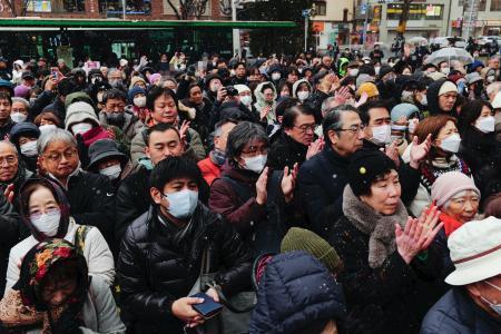 　雪が舞う中、街頭演説に集まった有権者＝７日午後、東京都内（政党ビラにモザイク加工しています）