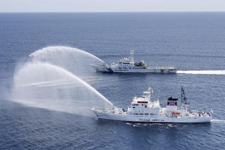　違法操業する外国漁船を想定して放水訓練をする海上保安庁（奥）と水産庁の船＝２０２３年、第９管区海上保安本部提供