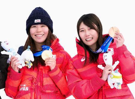 　ミラノ・コルティナ冬季五輪のスノーボード女子スロープスタイルの表彰式で、笑顔を見せる金メダルの深田茉莉（左）と銅メダルの村瀬心椛＝１８日、イタリア・リビーニョ（共同）