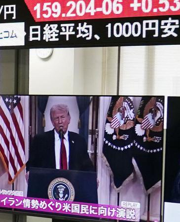 　下げ幅が一時１０００円超の日経平均株価を示すモニター（上）と、イラン情勢を巡るトランプ米大統領の演説を映すモニター＝２日午前、東京都港区の外為どっとコム