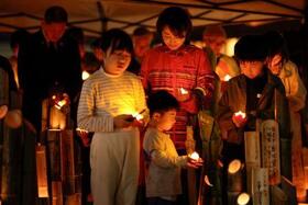 　熊本地震の「前震」から１０年となり、発生時刻に黙とうする子どもら＝１４日午後９時２６分、熊本県益城町
