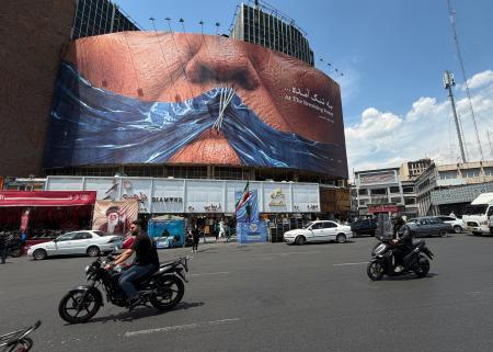 　封鎖状態のホルムズ海峡とトランプ米大統領の唇を描いた看板＝２日、イラン・テヘラン（ＡＰ＝共同）