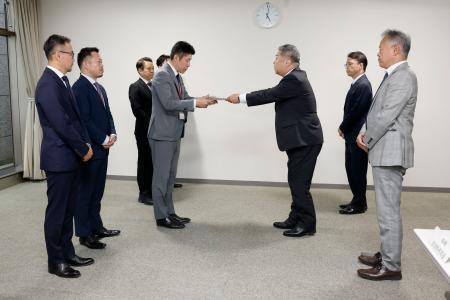 　さとふるの青木大介副社長（中央左）らに対し、手数料引き下げの要請書を渡す寺崎秀俊自治税務局長＝２２日午後、総務省