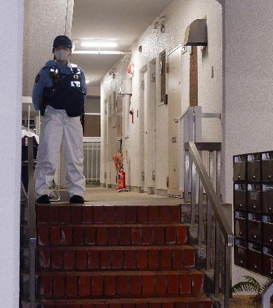　冷凍庫に入った男性の遺体が見つかった集合住宅を警戒する警察官＝２０日午後９時２６分、神戸市中央区