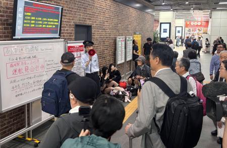 　地震の影響で運転見合わせとなった列車の運行情報を説明する駅員＝２５日午前８時３５分、ＪＲ盛岡駅