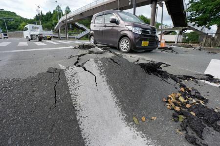 　地震の影響で変形した道路＝２９日午前８時３１分、熊本県氷川町