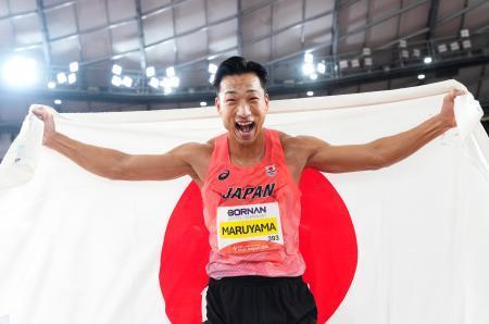 　男子十種競技で優勝し、日の丸を掲げる丸山優真＝パロマ瑞穂スタジアム