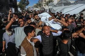 　イスラエル軍の攻撃で死亡した１６歳の少年の遺体を運ぶ人たち＝７日、パレスチナ自治区ガザ南部ハンユニス（ゲッティ＝共同）