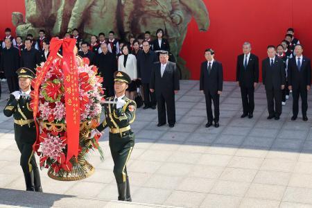 　朝鮮戦争の歴史を展示した博物館を訪れた北朝鮮の金正恩朝鮮労働党総書記（中央左）と中国共産党序列４位の王滬寧・人民政治協商会議（政協）主席（同右）＝２４日、中国遼寧省丹東市（新華社＝共同）