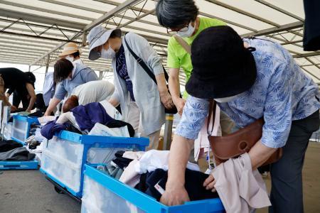 　ユニクロの出張販売会場で、商品を手に取る人たち＝２２日午前、石川県輪島市
