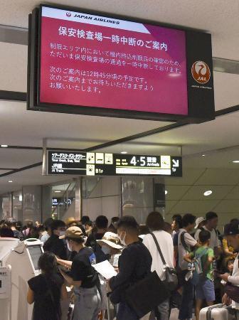 　新千歳空港で保安検査中断の案内を表示するモニター＝１７日