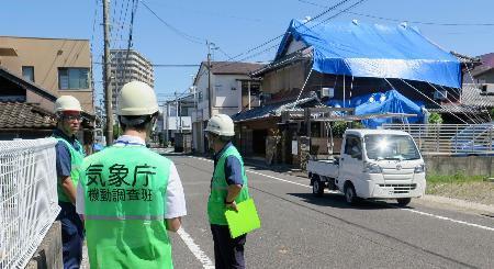 　突風による被害を受けた現場を調べる気象庁の担当者＝３１日午前１０時５１分、宮崎市