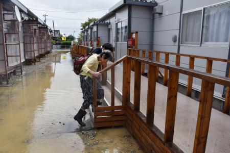 　水が引いた仮設住宅の自宅に戻る高齢の女性＝２２日午前、石川県珠洲市