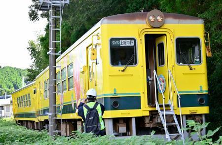 　いすみ鉄道の脱線した車両を調べる運輸安全委員会の鉄道事故調査官＝４日午後、千葉県いすみ市