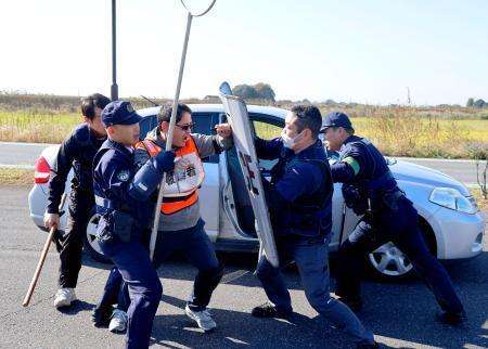 　群馬、茨城、栃木の３県警が行った訓練で、犯人役（中央）を取り押さえる警察官＝１２日午前、群馬県板倉町