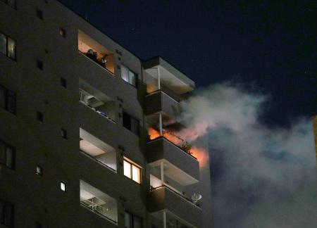 　炎が上がる川崎市川崎区のマンション＝２７日午後１０時２５分