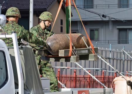 　名古屋市東区の建物解体現場で、回収される不発弾＝１５日午後