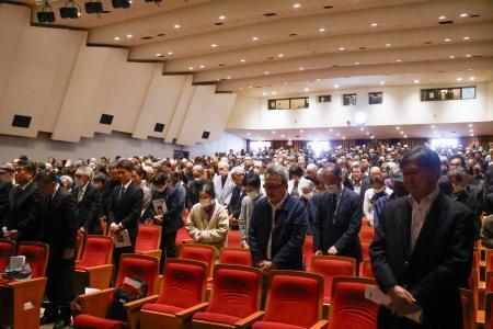 　石川一雄さんの追悼集会で黙とうする参加者ら＝１６日午後、東京都内