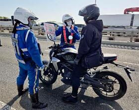 　東京都北区と埼玉県川口市を結ぶ新荒川大橋で、バイクの利用者を呼び止め安全運転を促す警視庁と埼玉県警の警察官＝２１日午前