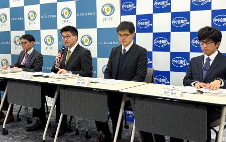 　記者会見する公取委の担当者ら＝２２日午後、東京都港区