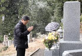 　スキーツアーバス転落事故で亡くなった次男・寛さんの墓に手を合わせる遺族会代表の田原義則さん＝１１日午後、京都府舞鶴市
