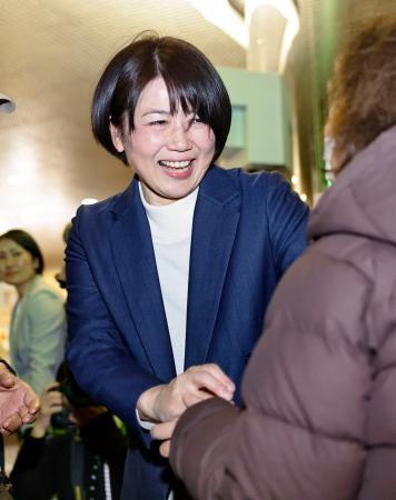 　前橋市長選で再選を決め、支持者と握手する小川晶氏＝１２日夜、前橋市
