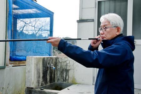 　吹き矢をかまえる「ＺＯＯＭＯ」の辻本恒徳園長＝２０２５年１１月、盛岡市