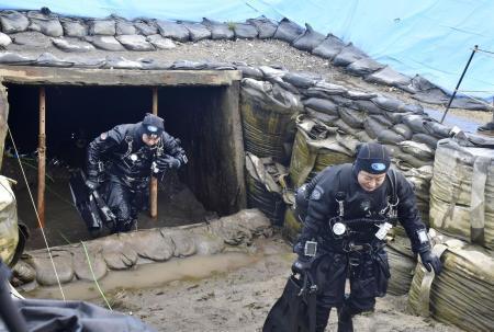 　２０２５年４月、「長生炭鉱」の潜水調査を終え、坑口から出てくるダイバー＝山口県宇部市