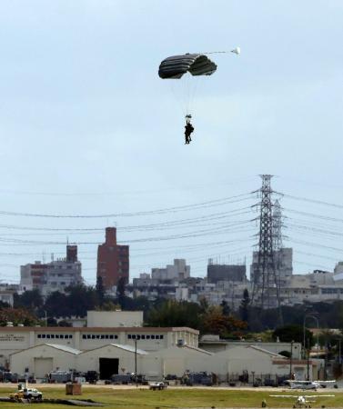 　沖縄県の米軍嘉手納基地で実施したパラシュート降下訓練で着地する米兵＝３日午後１時