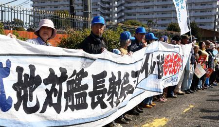 　ミサイル配備計画に抗議し、陸上自衛隊健軍駐屯地前で「人間の鎖」をつくる人たち＝２３日午後、熊本市