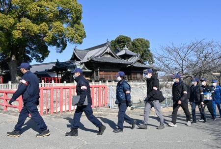 　「裸祭り」の会場となった西大寺観音院に向かう岡山県警の捜査員ら＝１１日午前、岡山市東区