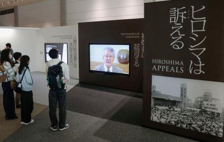 　原爆資料館の新設展示で、被爆証言映像を見る来館者＝２８日午後、広島市中区