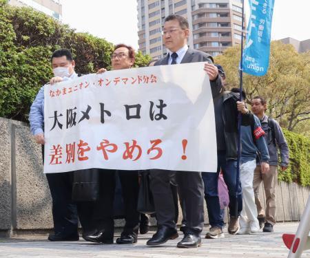 　大阪メトロを提訴するため大阪地裁に入る原告ら＝３０日午前