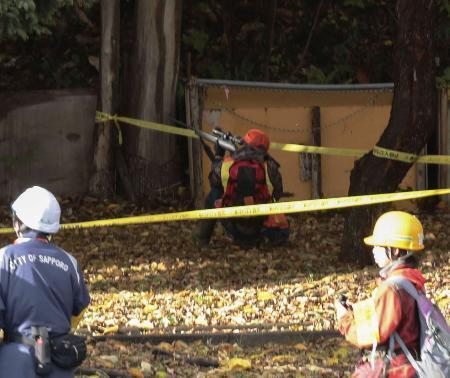 　「緊急銃猟」で銃を構える猟友会のハンター（奥）＝２０２５年１０月、札幌市西区