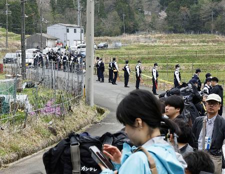 　安達結希さんの自宅付近に集まった報道陣と、警戒にあたる警察官＝１５日、京都府南丹市