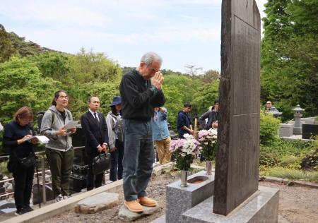 　朝鮮人労働者の慰霊碑の前で手を合わせる参列者＝１８日午後、群馬県太田市の金龍寺