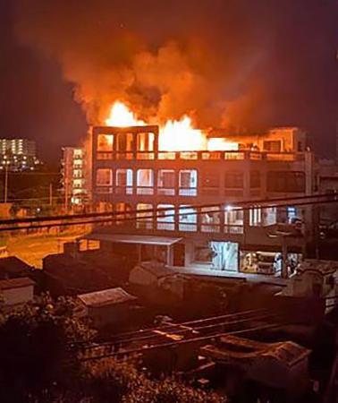 　炎が上がる集合住宅＝１９日未明、沖縄県沖縄市（近隣住民提供）