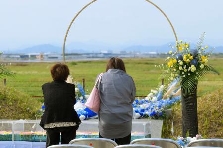 　中華航空機墜落事故から３２年となり、慰霊施設で献花し手を合わせる女性ら＝２６日午後、愛知県春日井市