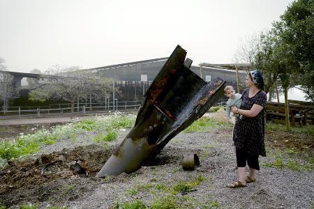 　ヨルダン川西岸のユダヤ人入植地で、イランから発射され着弾した弾道ミサイルを見るイスラエル人女性＝４月（ゲッティ＝共同）